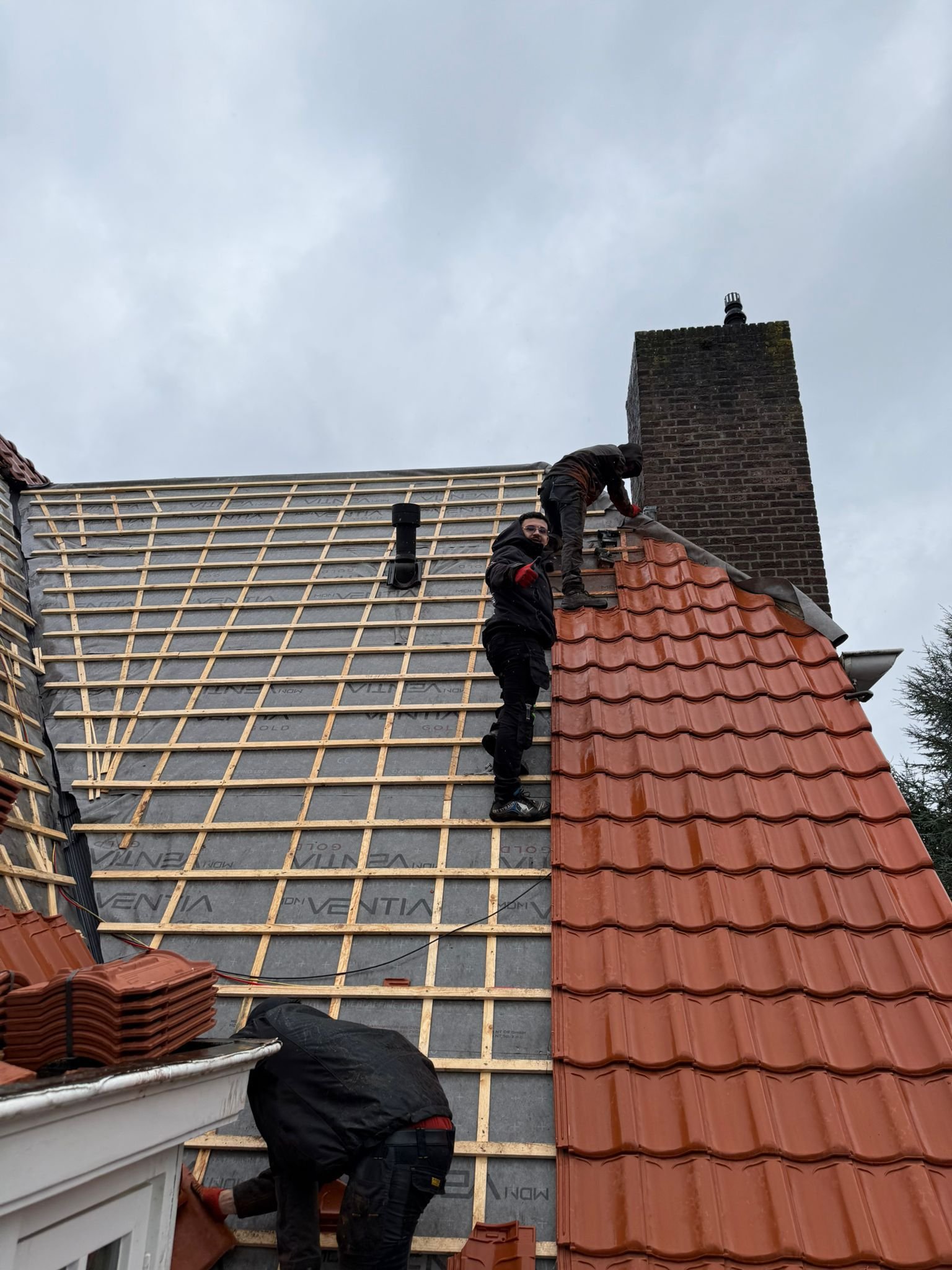 Dakdekker aan het werk op een hellend dak